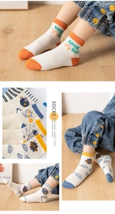 Detail of mesh breathable cotton kids socks with astronaut and star patterns on wood