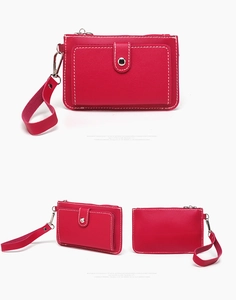 Detail view of red faux leather coin purse with contrast stitching and silver plating hardware
