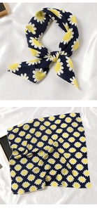 Détail du foulard en soie bleu marine à imprimé marguerites blanches avec nœud élégant