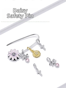 Detailed macro view of S925 silver daisy safety pin with enamel charms and pink heart pendant