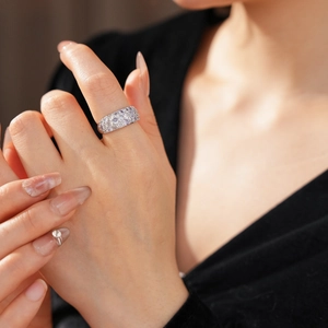 Nahaufnahme eines funkelnden Zirkonia Rings mit breiter Pavé Fassung an einer Hand