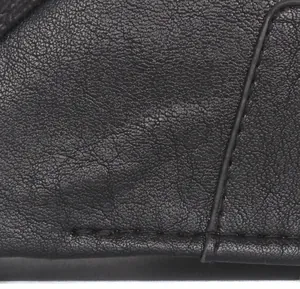 Close-up of precise stitching and pebble grain texture on a black leather newsboy cap