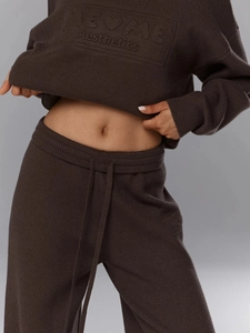 Close-up of the knitted texture and drawstring waist on dark brown wool blend set