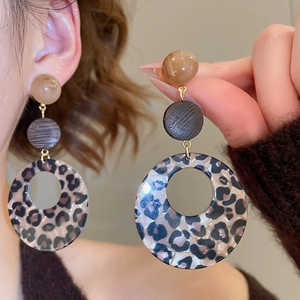 Detail of leopard print acrylic round drop earrings with vintage tortoiseshell texture
