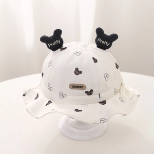 Détail d'un chapeau de soleil blanc pour bébé avec oreilles de Mickey et étiquette en cuir