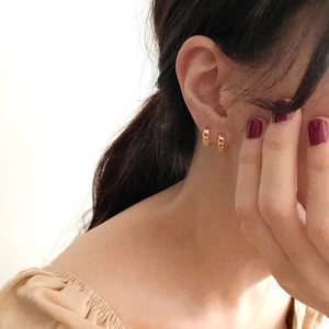Detail of 925 silver chain hoop earring in gold finish on a model's ear
