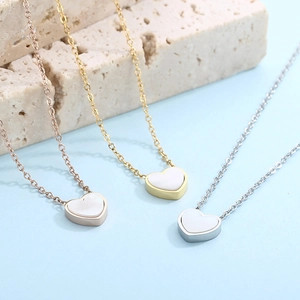 Detailed view of heart pendants in rose gold, gold, and silver with white shell inlay