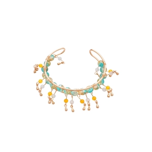 Bracelet jonc doré bohème avec pampilles en cristal et perles colorées sur fond blanc