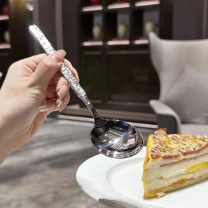 Macro shot of silver stainless steel spoon with embossed handle texture in a dining scene