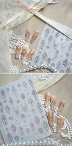 Detailed macro shot of 3D bronzing nail stickers featuring jewel and lace patterns