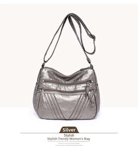Detail of silver textured PU leather crossbody bag with multiple zipper compartments