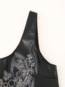 Detailed close-up of silver rhinestones and flower patterns on black PU leather top