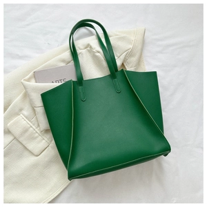 Detailed macro view showing the green lychee pattern leather texture on a tote bag