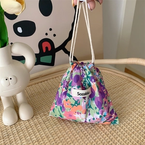 Close-up of floral drawstring bag with purple and green patterns on cotton linen fabric