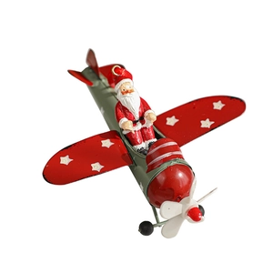Retro metal Santa Claus flying a red and green Christmas airplane ornament decoration