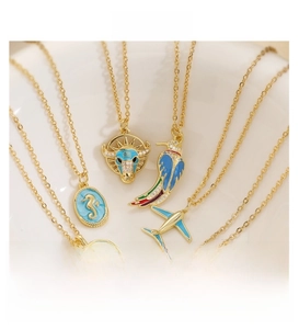 Detail of gold-plated seahorse and airplane pendants with colorful enamel and zircons