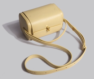 Vue de dessus d'un sac Boston en cuir jaune avec bandoulière et fermoir en métal doré
