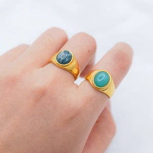 Detail of vintage 18k gold plated signet rings with blue and green gemstone inlay