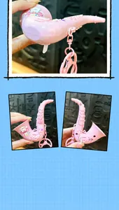 Macro view of a cute pink saxophone-shaped keychain with bear sticker