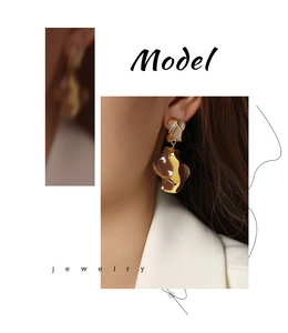 Close-up of elegant copper earrings with brown enamel inlay on model side profile