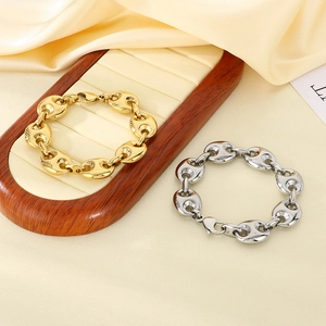 Close-up of 18k gold and silver stainless steel pig nose link bracelets on silk display
