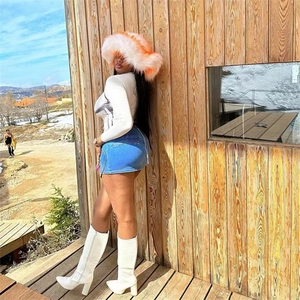 Detail of orange and white faux fur hat with thick winter texture in street style