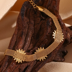 Detail of 18K gold-plated woven mesh bracelet featuring sunburst motifs and extension chain