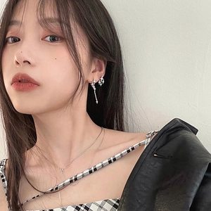 Asymmetric silver star earrings with zircons and tassels on a fashion model