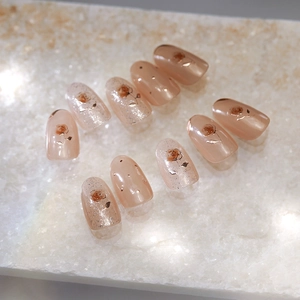Elegant press-on nails with golden rose embossment and silver glitter on pink base