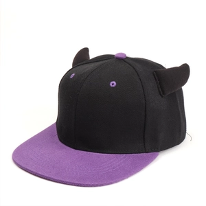 Detail shot of a black and purple flat brim hat featuring creative devil horns decoration