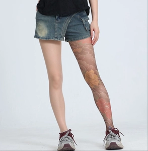 Detail of sheer nude tights featuring a colorful peony flower tattoo print on the leg