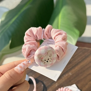 Pink scrunchie featuring a Yorkshire terrier button and soft pleated fabric textures