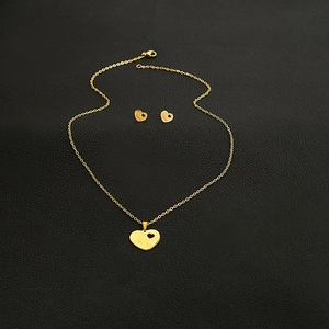 Detailed close-up of gold heart MOM jewelry set featuring necklace and earrings