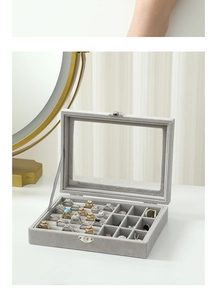 Detail showing the gray velvet jewelry box interior with rings and metal buckle