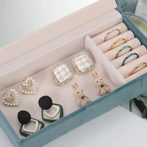 Deep green velvet jewelry box with pink lining, showing ring slots and earring display