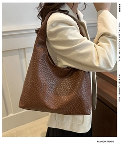 Sac fourre-tout marron en similicuir tressé porté à l'épaule avec un blazer chic