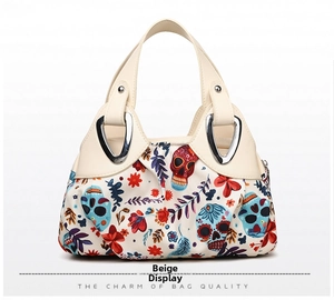 Close-up of off-white leather handbag featuring colorful skull and flower prints