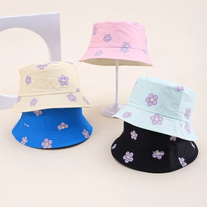 Detail of colorful children sun hats with cartoon flower prints on white display stands