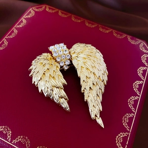 Broche ailes vintage dorée avec strass sur boîte à bijoux rouge accessoire de mode