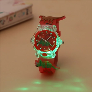 Close-up of kids dinosaur watch showing green LED luminous effect and red silicone strap