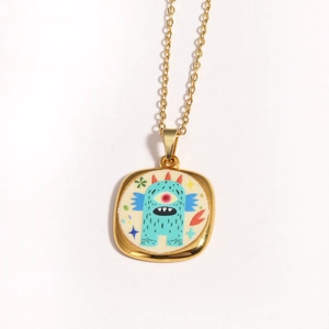 Close-up of golden enamel monster pendant with evil eye and star details
