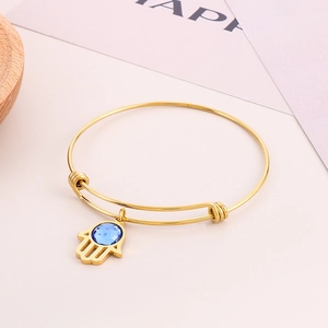 Dettaglio del bracciale regolabile Mano di Fatima oro con strass blu sfaccettato