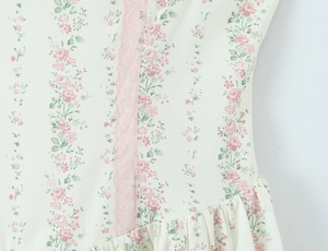 Dettaglio vestito floreale con finiture in pizzo rosa e bordi in chiffon a balze