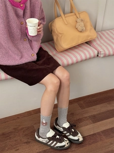 Detail of grey crew socks featuring cute brown bear embroidery and soft knit texture