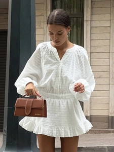 Détail de la mini robe blanche brodée avec ourlet à volants et coton texturé