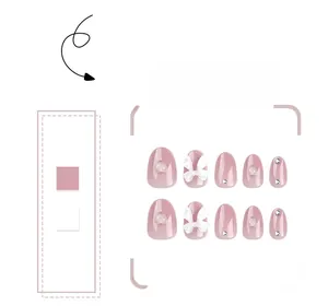 Détail de faux ongles roses avec nœuds blancs 3D, motifs de cœurs et petits strass brillants