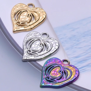 Close-up of heart-shaped hollow metal pendants in gold, silver, and rainbow finishes