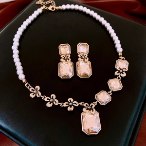 Detailed macro view of gold-tone floral necklace set with champagne crystals and pearls