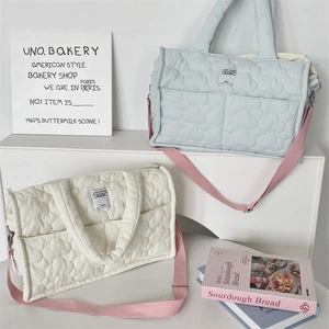 Close-up of quilted tote bags with Cloud Hugger label and contrast pink straps