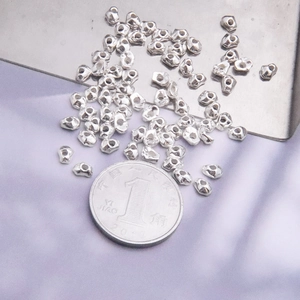 Irregular S925 sterling silver beads for DIY jewelry making shown next to a coin